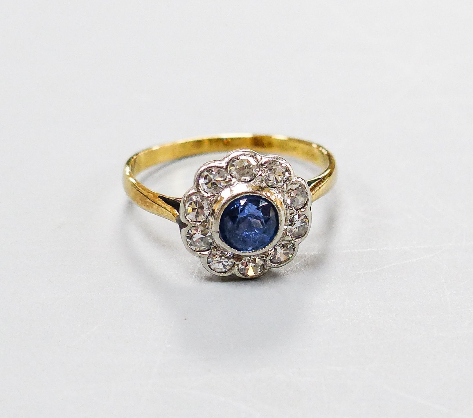 A yellow metal, sapphire and diamond cluster set flower head ring, size G, gross weight 1.6 grams.